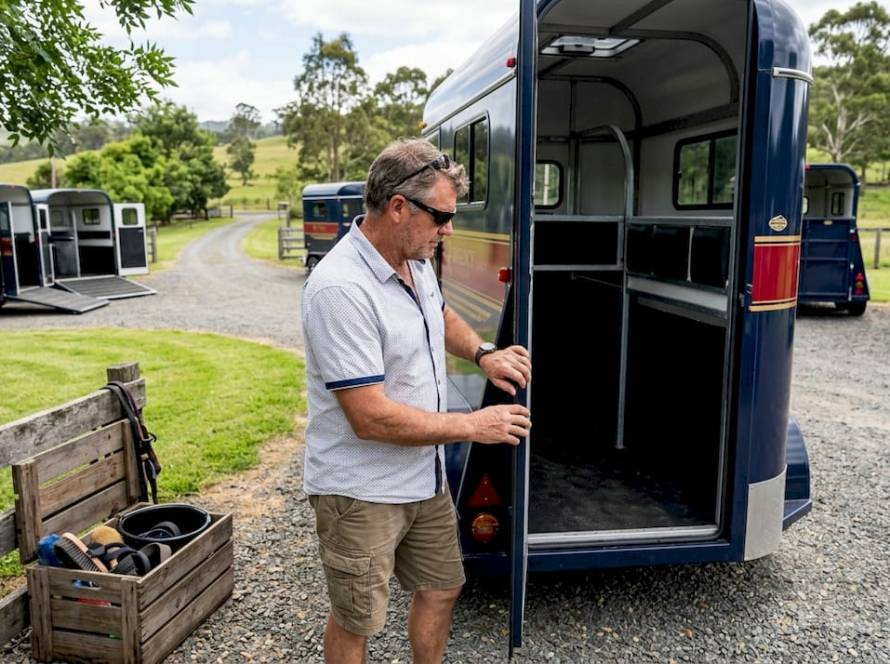 Man inspecting horse float at farm dealership
